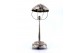  Candeeiro de mesa em prata recortada assente em base circular com motivos florais relevados, eletrificado, e com três pés em forma de folhas de acanto.